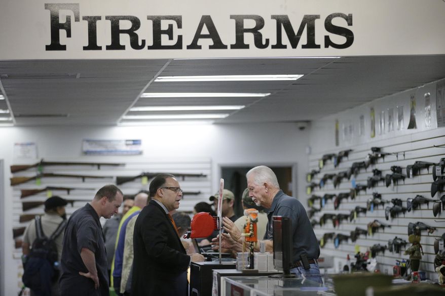 FILE - In this Dec. 9, 2015, file photo, sales associate Mike Conway, right, shows Paul Angulo a pistol at Bullseye Sport gun shop in Riverside, Calif. Gov. Jerry Brown has signed a new law requiring that Californians undergo at least eight hours of training, including live fire exercises, before carrying concealed weapons. (AP Photo/Jae C. Hong, File)