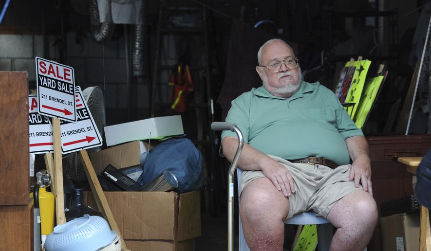 Willie Davis, a US Navy veteran who is dying from cancer, sits in his garage among many of his belongings, which he's trying to sell to help pay for his own funeral, Wednesday, Sept. 26, 2018, in Johnstown, Pa. (John Rucosky/Tribune-Democrat via AP)