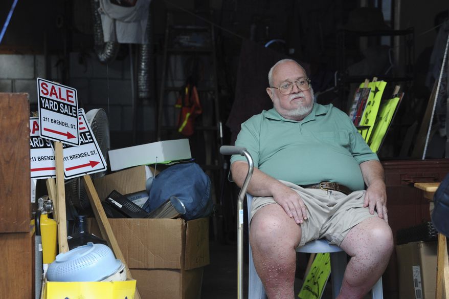 Willie Davis, a US Navy veteran who is dying from cancer, sits in his garage among many of his belongings, which he's trying to sell to help pay for his own funeral, Wednesday, Sept. 26, 2018, in Johnstown, Pa. (John Rucosky/Tribune-Democrat via AP)