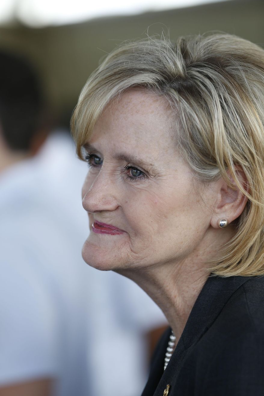 In this Friday, Sept. 7, 2018 photo, appointed Republican U.S. Sen. Cindy Hyde-Smith, R-Miss., looks at a group of farmers and ranchers during a Greenwood, Miss., campaign stop. Hyde-Smith is running in a special election in November to fill the unexpired term of U.S. Sen. Thad Cochran, R-Miss., who retired in April. She faces fellow Republican, state Sen. Chris McDaniel, who almost unseated Cochran four years ago, Mike Espy, a Democrat and President Bill Clinton's first agriculture secretary, and Tobey Bernard Bartee, a former military intelligence officer who is also a Democrat. Party labels do not appear on the ballot. (AP Photo/Rogelio V. Solis)