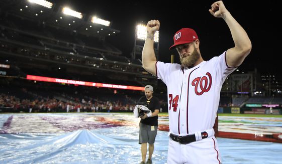 Washington Nationals Bryce Harper (34) bows his head and raise his arms with clenched fists as the Nationals celebrate and bid goodbye to their fans ending their last home game of the season with a 9-3 rain delayed win against the Miami Marlins in Washington, Wednesday, Sept. 26, 2018. (AP Photo/Manuel Balce Ceneta) ** FILE **