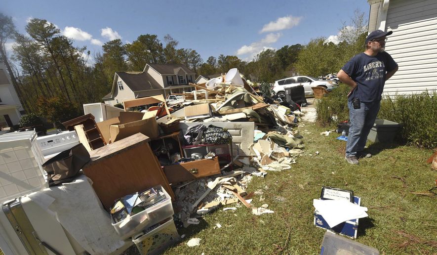 Brian Morris looks at the debris from his home in the Stoney Creek Plantation neighborhood Wednesday, Sept. 26, 2018, in Leland, N.C. Many of the homes here were flooded through their bottom floors due to rains from Hurricane Florence. (Ken Blevins /The Star-News via AP)
