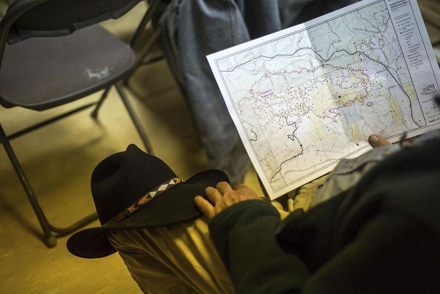 A resident looks over a fire perimeter map during a public informational meeting, Tuesday, Sept. 25, 2018, at Bondurant School in Bondurant, Wyo. (Ryan Dorgan/Jackson Hole News & Guide via AP)