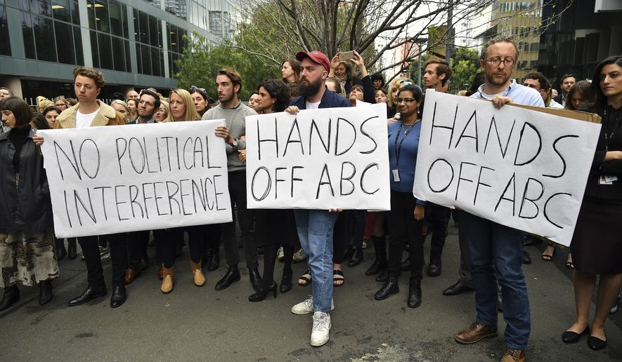 In this Wednesday, Sept. 26, 2018, photo, Australian Broadcasting Corp. staff hold placards outside their offices in Sydney, Australia. The chairman of the Australian Broadcasting Corp. resigned on Thursday over allegations that he pressured the independent national broadcaster to fire two political journalists because the government disliked them. (Joel Carrett/AAP Image via AP)