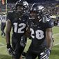 Central Florida linebacker Shawn Burgess-Becker (28) celebrates his 40-yard pass interception for a touchdown against Florida Atlantic with teammate linebacker Eric Mitchell (12) during the second half of an NCAA college football game, Friday, Sept. 21, 2018, in Orlando, Fla. (AP Photo/John Raoux)
