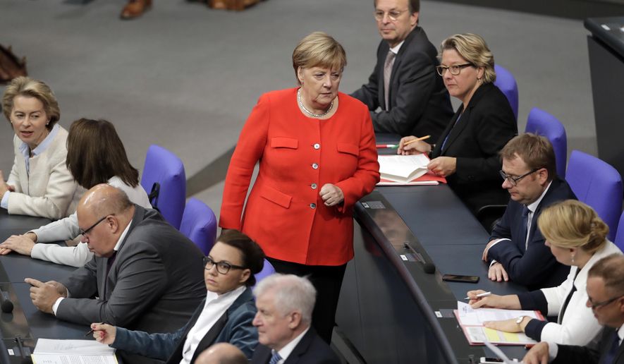 German Chancellor Angela Merkel, center, walks between ministers and state secretaries during a meeting of the German federal parliament, Bundestag, at the Reichstag building in Berlin, Germany, Thursday, Sept. 27, 2018. (AP Photo/Michael Sohn)