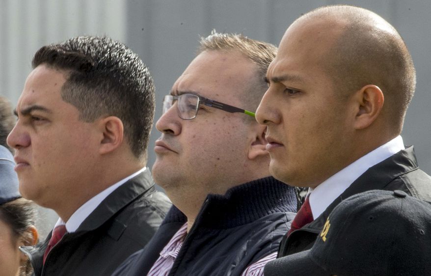 FILE- In this July 17, 2017 file photo, Mexico's former Veracruz state Gov. Javier Duarte, center, is escorted by police to an aircraft as he is extradited to Mexico City, at an Air Force base in Guatemala City. Mexican prosecutors said Thursday, Sept. 27, 2018, that Duarte pleaded guilty to charges of organized crime and money laundering. (AP Photo/Moises Castillo, File)