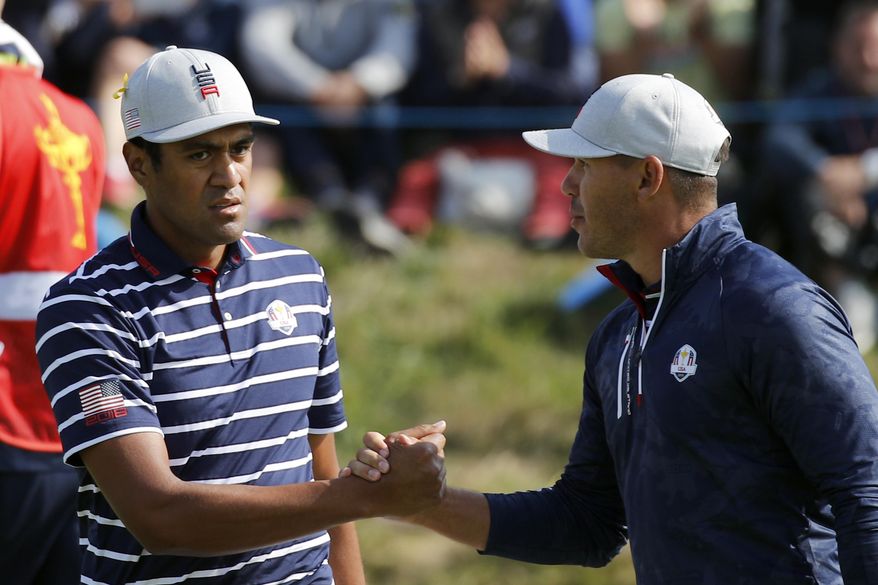 Tony Finau of the US, left, and his teammate Brooks Koepka congratulate each other on the 15th during their fourball match against Europe players Justin Rose and Jon Rahm on the opening day of the 42nd Ryder Cup at Le Golf National in Saint-Quentin-en-Yvelines, outside Paris, France, Friday, Sept. 28, 2018. (AP Photo/Francois Mori)