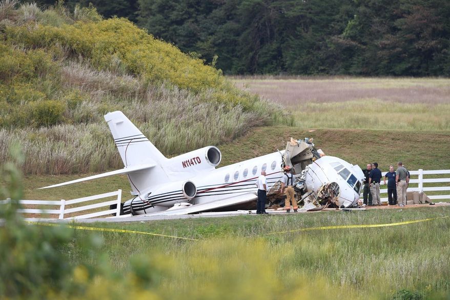 Emergency personnel responding after an aircraft crashed onto Airport Road in Greenville, S.C. The mid-sized jet that tried to land at a South Carolina airport and ran off the runway and split in two, killing the two pilots on board and injuring two passengers. Witnesses say the plane appeared to land without a problem until it overshot the runway and went down a steep embankment. (Bart Boatwright/The Greenville News via AP)