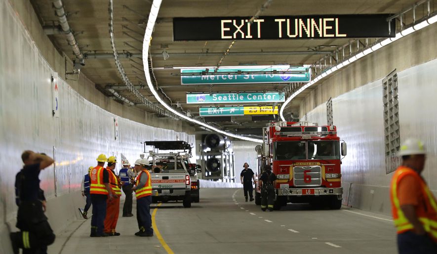 A Seattle Fire Dept. truck, right, backs out of the tunnel that will eventually replace the Alaskan Way Viaduct following an emergency drill Thursday, Sept. 27, 2018, in Seattle. Multiple federal, state, and local agencies conducted the drill Thursday ahead of the tunnel's planned opening in 2019. The drill included a staged multi-vehicle crash, volunteers simulating injured travelers, emergency response crews and activation of the tunnel's deluge fire suppression system. (AP Photo/Ted S. Warren, Pool)