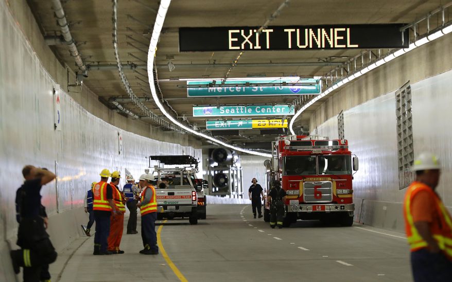 A Seattle Fire Dept. truck, right, backs out of the tunnel that will eventually replace the Alaskan Way Viaduct following an emergency drill Thursday, Sept. 27, 2018, in Seattle. Multiple federal, state, and local agencies conducted the drill Thursday ahead of the tunnel's planned opening in 2019. The drill included a staged multi-vehicle crash, volunteers simulating injured travelers, emergency response crews and activation of the tunnel's deluge fire suppression system. (AP Photo/Ted S. Warren, Pool)