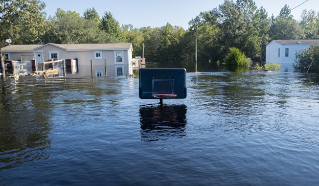 A basketball net barely sticks up above the flood waters at Lee&#x27;s Landing in Conway, S.C., Wednesday, Sept. 26, 2018. Predictions for the final communities in the path of Hurricane Florence&#x27;s flooding aren&#x27;t as dire as they once were. Officials originally expected flooding in the worst areas of Georgetown County to be from 5 to 10 feet. But the latest forecast lowered that estimate and the Waccamaw River in Conway has been at the same level for nearly a day. (Jason Lee/The Sun News via AP)
