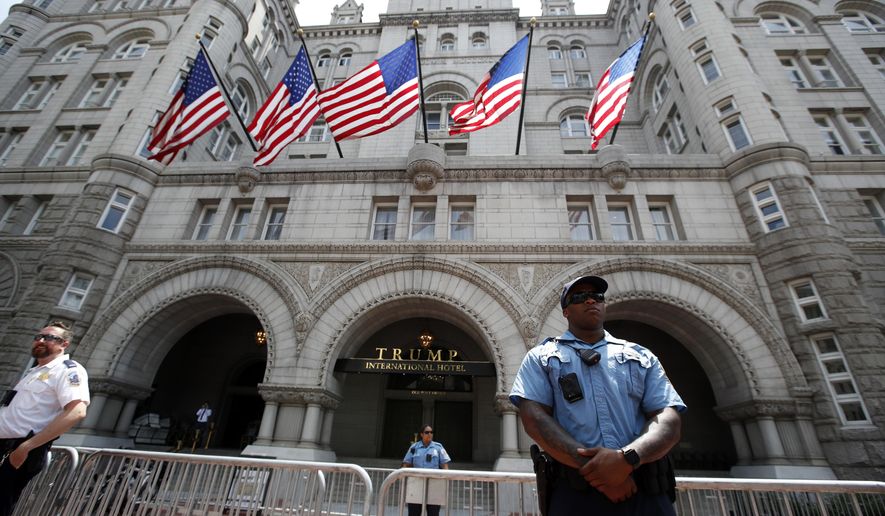 In this June 30, 2018, photo, law enforcement officers stand guard in front of the Trump Hotel in Washington. (AP Photo/Alex Brandon) **FILE**