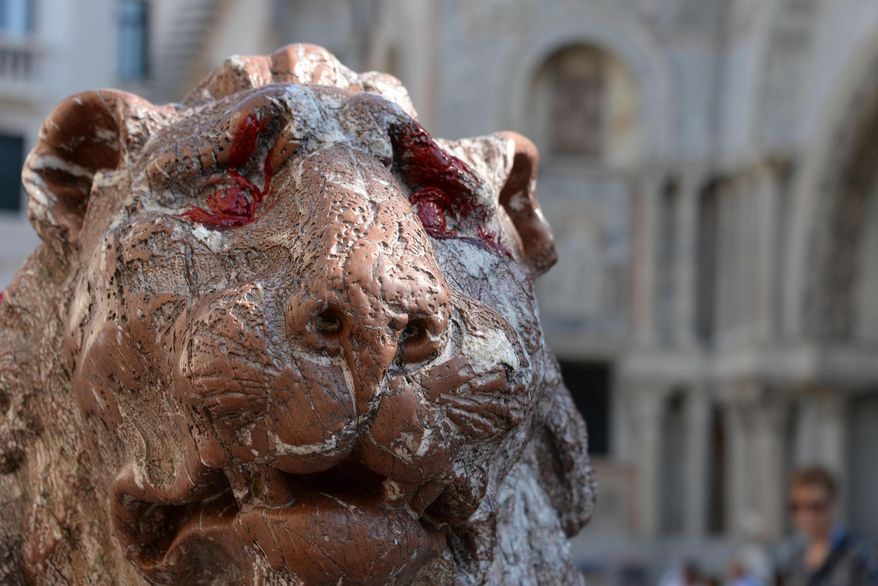 A stone lion next to St. Mark's Basilica, its eyes stained with red paint, is seen in Venice, Italy, Saturday, Sept. 29, 2018. One of the two stone lions that stand guard next to Venice's famed St. Mark's Basilica has been vandalized with red paint. Residents raised the alarm early Saturday after noticing the paint splashed on the eyes and mane of the red marble "leoncino" statue, located on a small piazza next to the basilica. (Andrea Merola/ANSA via AP)