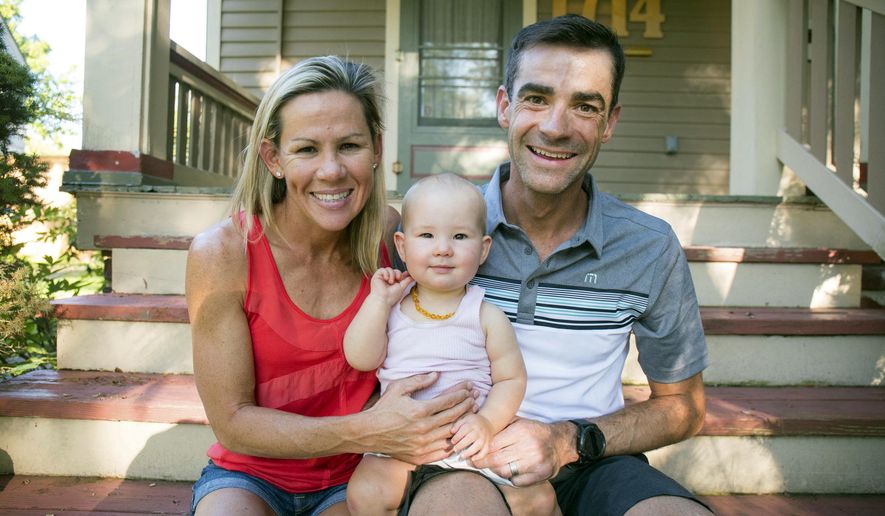 In this undated photo, three-time Ironman world champion Mirinda Carfrae, left, and her husband, elite triathlete Tim O&#39;Donnell pose with their 1-year-old daughter Isabelle during a break in their training camp in Lawrence, Kan. Carfrae and O&#39;Donnell are among the favorites for next month&#39;s Ironman world championships in Kona, Hawaii (Talbot Cox via AP)
