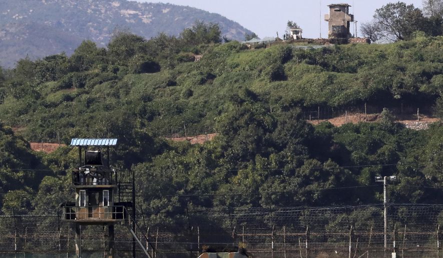 In this on Sunday, Sept. 30, 2018 photo, military guard posts of North Korea, right top, and South Korea, left bottom, are seen in Paju, at the border with North Korea, South Korea. Seoul on Monday, Oct. 1, 2018, says South Korea has begun clearing mines from two sites inside the heavily fortified border with North Korea under a package of tension-reduction deal between the rivals. (Kim Do-hoon/Yonhap via AP)