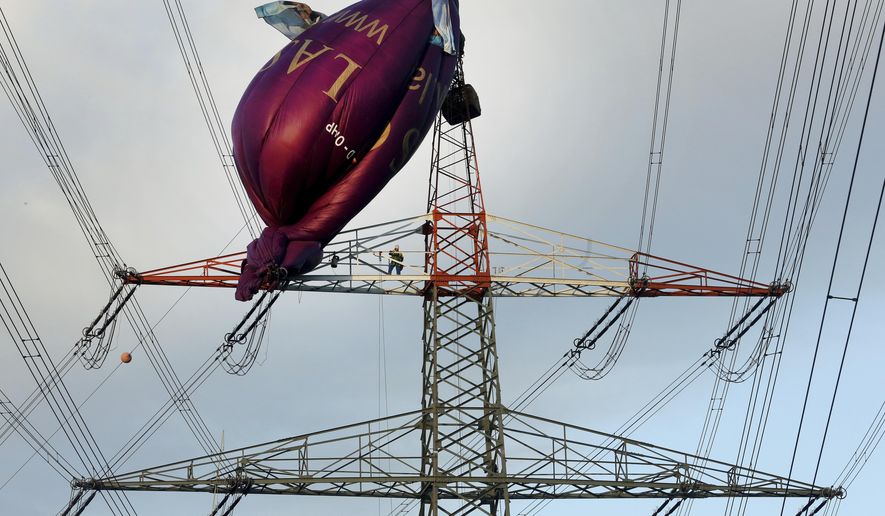 A hot air balloon sits on top of a high-voltage power line in Bottrop, Monday, Oct. 1, 2018 after it collided the evening before. Six passengers were rescued from a height of 65 meters (210 feet). (Roland Weihrauch/dpa via AP)