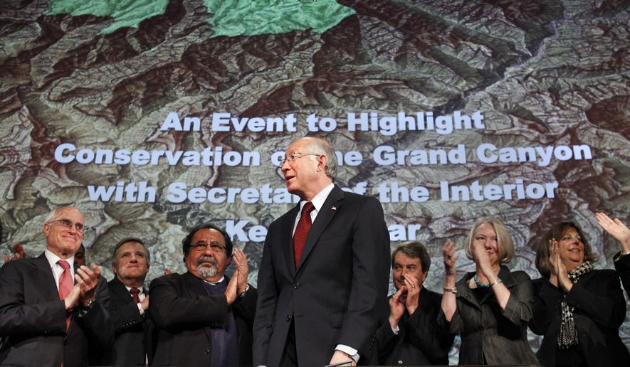 File - In this Jan. 9, 2012 file photo, then Interior Secretary Ken Salazar, center, standing in front of a map of the Grand Canyon, is applauded after announcing a twenty year ban on new mining claims near the Grand Canyon in Washington. The U.S. Supreme Court has denied review of an Obama-era action that put nearly 1 million acres near the Grand Canyon off-limit to new mining claims. Environmentalists hailed the decision Monday, Oct. 1, 2018, but say they're worried the Trump administration is working to end the ban administratively. (AP Photo/Jacquelyn Martin, File)