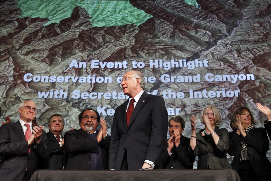 File - In this Jan. 9, 2012 file photo, then Interior Secretary Ken Salazar, center, standing in front of a map of the Grand Canyon, is applauded after announcing a twenty year ban on new mining claims near the Grand Canyon in Washington. The U.S. Supreme Court has denied review of an Obama-era action that put nearly 1 million acres near the Grand Canyon off-limit to new mining claims. Environmentalists hailed the decision Monday, Oct. 1, 2018, but say they're worried the Trump administration is working to end the ban administratively. (AP Photo/Jacquelyn Martin, File)
