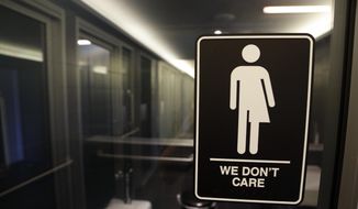 This May 12, 2016, file photo, shows signage outside a restroom at 21c Museum Hotel in Durham, N.C. (AP Photo/Gerry Broome, File)