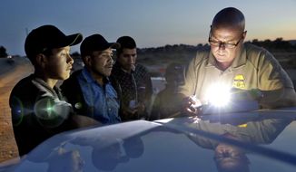 A U.S. Customs and Border Patrol agent gathers information on four Guatemalan nationals, including two men and a pair of 12 and 13-year-old boys, Wednesday, July 18, 2018, in Yuma, Ariz. Thousands of families and unaccompanied children are continuing to cross the U.S. border in Arizona and California even after learning of the government&#39;s family separation policy upon apprehension. (AP Photo/Matt York) ** FILE **