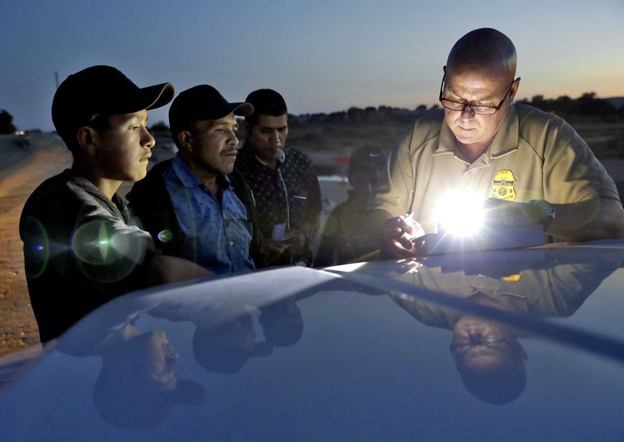 A U.S. Customs and Border Patrol agent gathers information on four Guatemalan nationals, including two men and a pair of 12 and 13-year-old boys, Wednesday, July 18, 2018, in Yuma, Ariz. Thousands of families and unaccompanied children are continuing to cross the U.S. border in Arizona and California even after learning of the government&#39;s family separation policy upon apprehension. (AP Photo/Matt York) ** FILE **