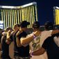 Survivors return to the scene of a mass shooting on the first anniversary, Monday, Oct. 1, 2018, in Las Vegas. Hundreds of survivors of the Las Vegas mass shooting have formed a human chain around the shuttered site of a country music festival where a gunman opened fire last year. (AP Photo/John Locher)