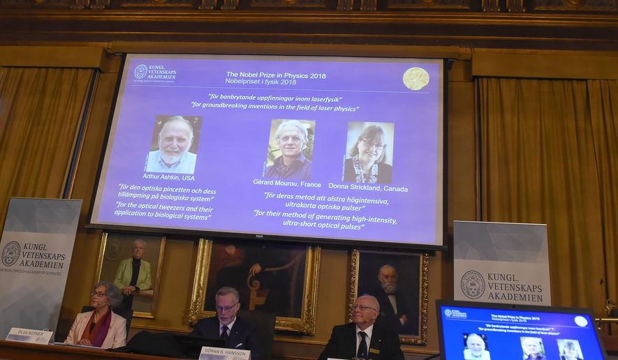 The Nobel Prize laureates for physics 2018 shown on the screen from left, Arthur Ashkin of the United States, Gerard Mourou of France and Donna Strickland of Canada during the announcement at the Royal Swedish Academy of Sciences in Stockholm, Sweden, Tuesday Oct. 2, 2018. The three scientists from the United States, France and Canada have been awarded the Nobel Prize in physics for advances in laser physics. (Hanna Franzen/TT via AP)