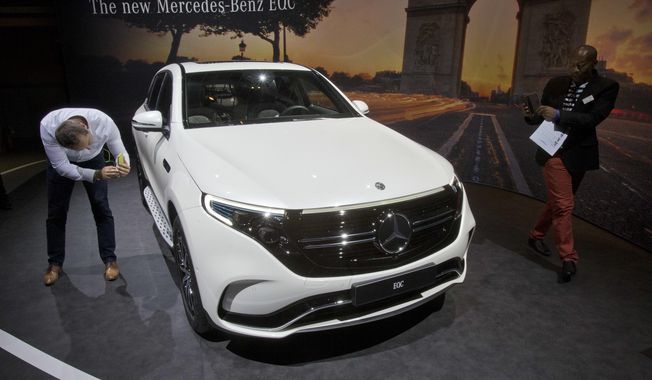 Media people look at a Mercedes-Benz EQC, electric luxury SUV during a media presentation on the eve of Paris Auto Show in Paris, France, Monday, Oct. 1, 2018. Doubts about diesel, Brexit, trade worries, tighter emissions controls. Those are the challenges that will be on the minds of auto executives when they gather this week ahead of the Paris Motor Show at the Porte de Versailles exhibition center. (AP Photo/Michel Euler)