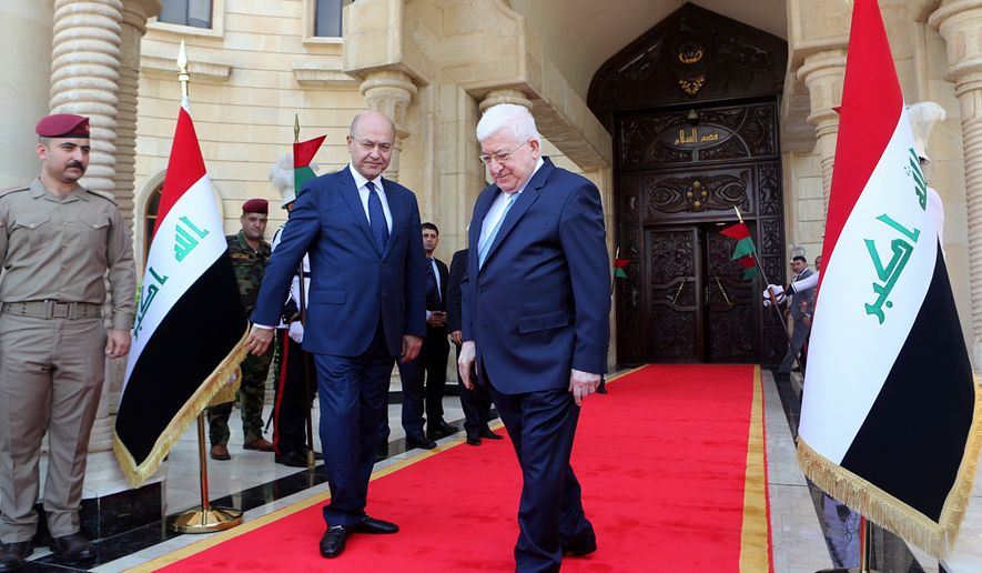 Former Iraqi President Fuad Masum, center, leaves the presidency headquarters in the peace palace after the inauguration ceremony for the newly elected Iraqi President Barham Salih, center left, in Baghdad, Iraq, Wednesday, Oct. 3, 2018. Iraq&#x27;s new president takes office after tapping Adel Abdul-Mahdi, 76, an independent Shiite politician and former vice president for the post of prime minister. (AP Photo/Khalid Mohammed)