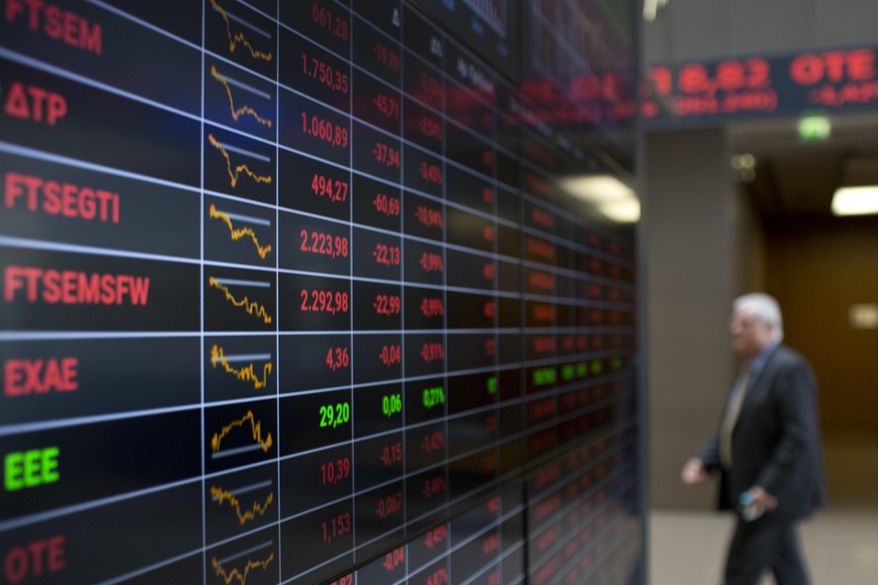 An employee of Athens Stock Exchange walks past screens showing falling stocks in red, in Athens, Wednesday, Oct. 3, 2018. Greek banking shares are down sharply amid investor fears over the lenders' needs to reduce their large stock of bad loans resulting from the financial crisis. The index of bank stocks was down 10 percent in Athens on Wednesday amid reports that some of the bigger banks plan to more aggressively write off bad loans. (AP Photo/Petros Giannakouris)