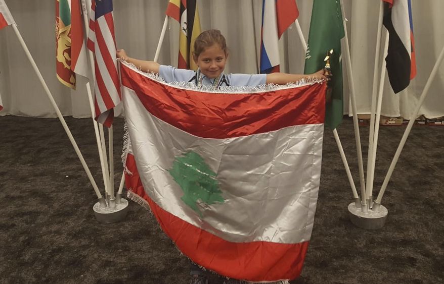 This Sept. 30, 2018 photo provides by Rochana Atmeh, shows Jennifer Maria Hektor, 8, born to a Swedish father and Rochana Atmeh, her Lebanese mother, holding a Lebanese flag, in Johannesburg, South Africa. Hektor won runner-up place in an international mental calculation competition in South Africa representing Lebanon. But the 8-year old doesn't have Lebanese citizenship. Human Rights Watch called on Lebanese authorities to amend a 1925 law that discriminates against Lebanese mothers, denying them the right to pass on citizenship to their children. (Rochana Atmeh via AP)
