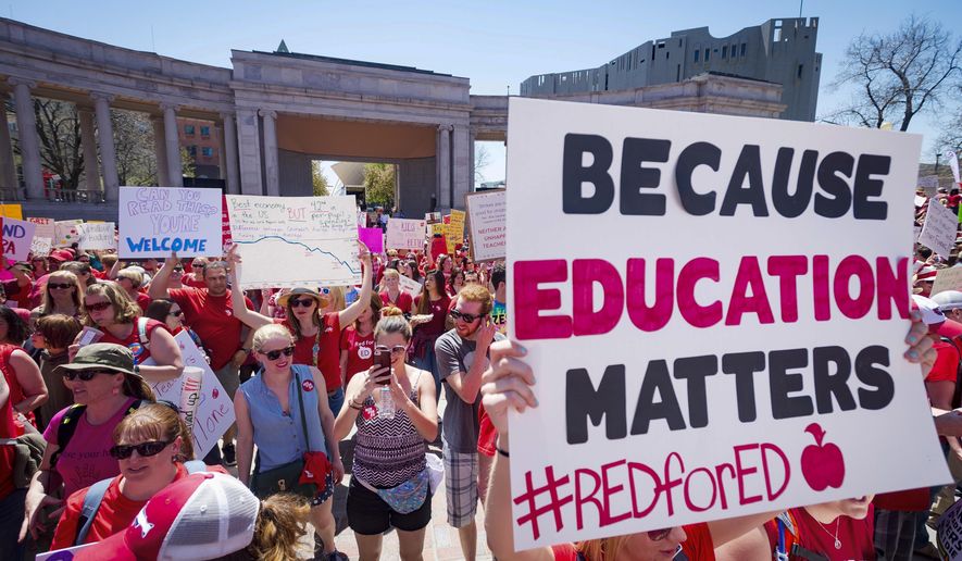 FILE - In this April 27, 2018 file photo a sign reads &amp;quot;Because education matters, #redfored&amp;quot; as thousands of teachers and supporters begin their rally from the amphitheater at Civic Center Park in Denver. Teachers have been making their mark in the U.S. midterm elections, running in what may be unprecedented numbers and empowered by the successful #RedForEd protests for higher teacher pay and increased school spending.  (Dougal Brownlie/The Gazette via AP, File)