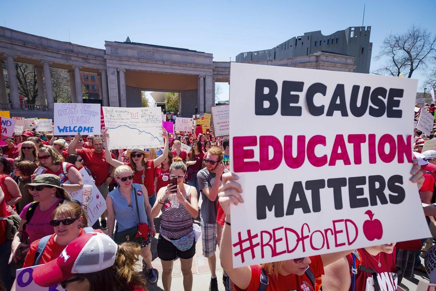FILE - In this April 27, 2018 file photo a sign reads "Because education matters, #redfored" as thousands of teachers and supporters begin their rally from the amphitheater at Civic Center Park in Denver. Teachers have been making their mark in the U.S. midterm elections, running in what may be unprecedented numbers and empowered by the successful #RedForEd protests for higher teacher pay and increased school spending. (Dougal Brownlie/The Gazette via AP, File)
