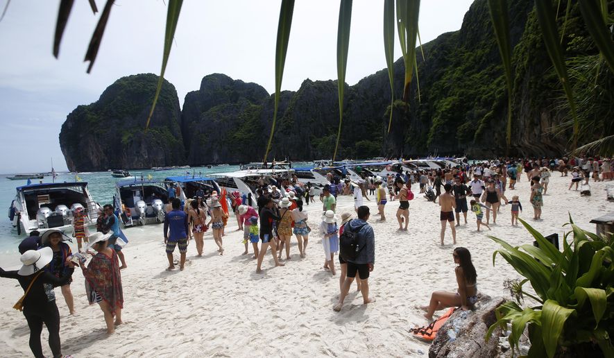 In this photo taken Thursday, May 31, 2018, tourists enjoy the beach on Maya Bay, Phi Phi Leh island in Krabi province, Thailand. Maya Bay will close to tourists indefinitely until its ecosystem returns to its full condition, the Department of National Parks, Wildlife and Plant Conservation said in a Monday announcement published on the Royal Gazette. (AP Photo/Sakchai Lalit)