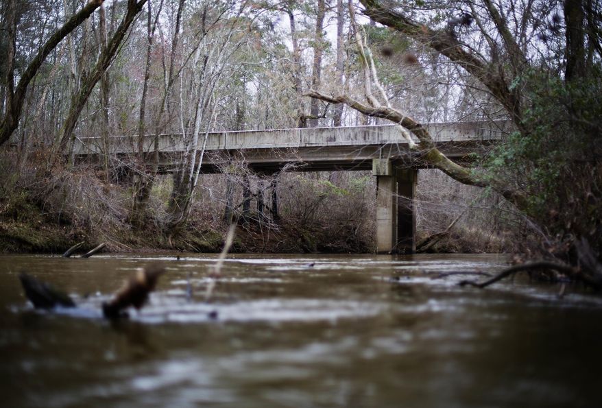 FILE- This Feb. 22, 2018 photo shows a bridge that spans the Apalachee River at Moore's Ford Road where in 1946 two young black couples were stopped by a white mob who dragged them to the riverbank and shot them multiple times in Monroe, Ga. The brazen mass lynching horrified the nation that year but no one was ever indicted and investigations over the years failed to solve the case. More than 70 years after a grand jury failed to indict anyone in the lynching of two young black couples in rural Georgia, a historian is seeking the transcripts from the grand jury proceedings. A federal appeals court is set to hear arguments in the case Wednesday, Oct. 3, 2018. (AP Photo/David Goldman, File)
