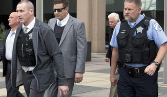Chicago Police Officer Jason Van Dyke, wearing sunglasses, is escorted out of the Leighton Criminal Court Building in Chicago, Tuesday, Oct. 2, 2018, after testifying in his first degree murder trial for the shooting death of Laquan McDonald. (AP Photo/Teresa Crawford)