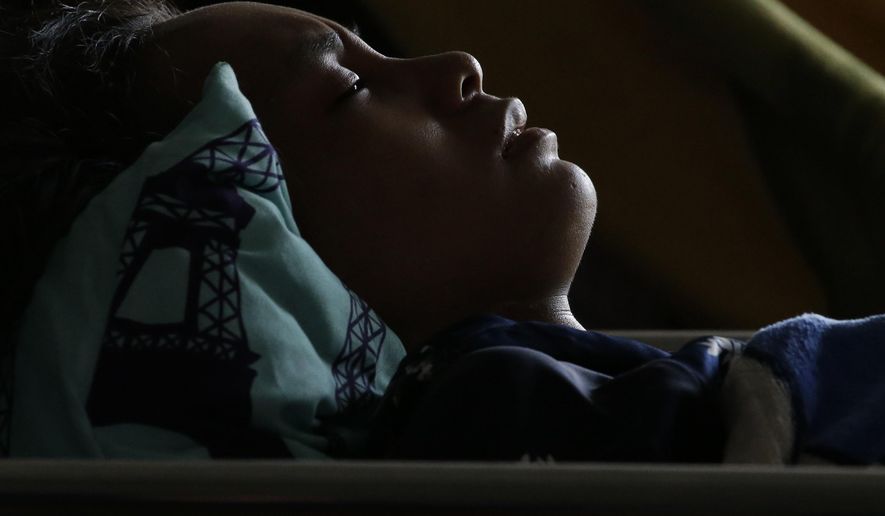 Anisa Cornelia grimaces in pain as she lies inside a medical tent after being injured in a massive earthquake and tsunami in Palu, Central Sulawesi, Indonesia Thursday, Oct. 4, 2018. All she could think of was the love of her life, the man she was supposed to marry this month. She had not seen him since a deadly tsunami smashed into the Indonesian city of Palu last week, separating the pair possibly forever as they strolled along a sandy beach at twilight. (AP Photo/Aaron Favila)