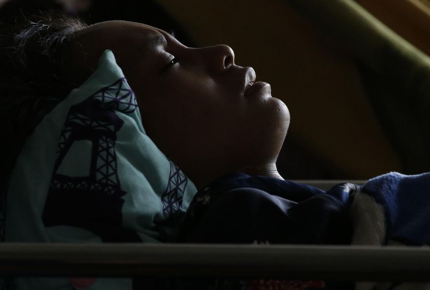 Anisa Cornelia grimaces in pain as she lies inside a medical tent after being injured in a massive earthquake and tsunami in Palu, Central Sulawesi, Indonesia Thursday, Oct. 4, 2018. All she could think of was the love of her life, the man she was supposed to marry this month. She had not seen him since a deadly tsunami smashed into the Indonesian city of Palu last week, separating the pair possibly forever as they strolled along a sandy beach at twilight. (AP Photo/Aaron Favila)