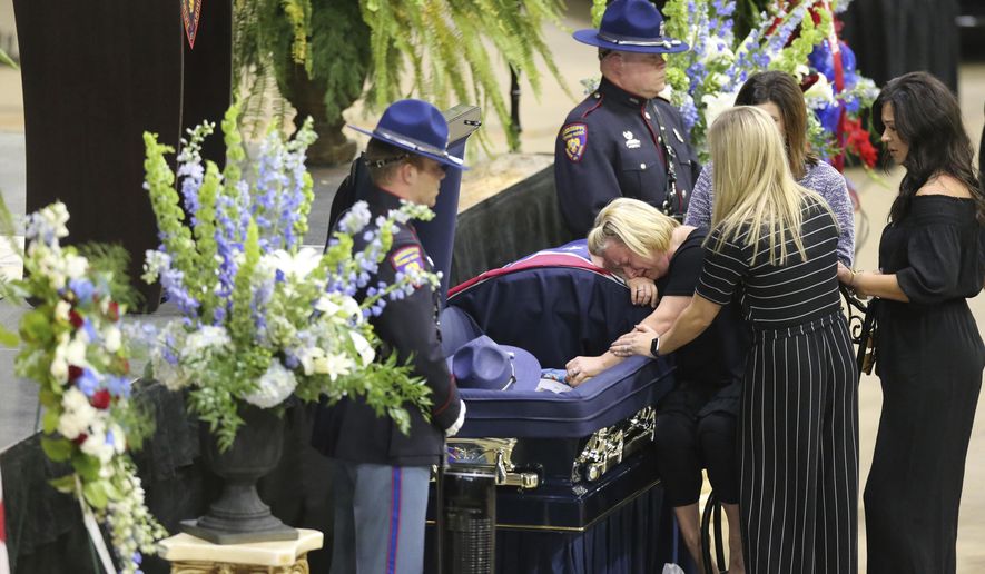 Chelsea Smith is surrounded by family and friends as she mourns the loss of her husband, Mississippi Highway Patrol Officer Cpl. Kenneth Smith, before his service Thursday, Oct. 4, 2018, afternoon in Corinth, Miss.(Thomas Wells/The Northeast Mississippi Daily Journal via AP)