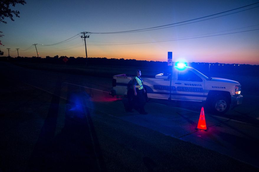Officials block roads where one student died when a Mesquite Independent School District bus rolled into a ditch with 42 students on board in Mesquite, Texas on Wednesday, Oct. 3, 2018. (Shaban Athuman/The Dallas Morning News via AP)