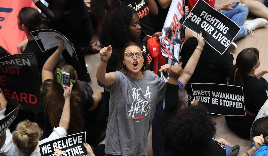 A demonstrator protests against Supreme Court nominee Brett Kavanaugh and chant slogans during a rally in the atrium of the Hart Senate Office Building on Capitol Hill in Washington, Thursday, Oct. 4, 2018. (AP Photo/Manuel Balce Ceneta)