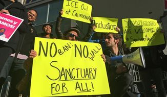 In this April 14, 2017, photo, protesters rally outside a courthouse in San Francisco. U.S. Judge William Orrick struck down an immigration law Friday, Oct. 5, 2018, that the Trump administration has used to go after cities and states that limit cooperation with immigration officials. (AP Photo/Haven Daley) **FILE**