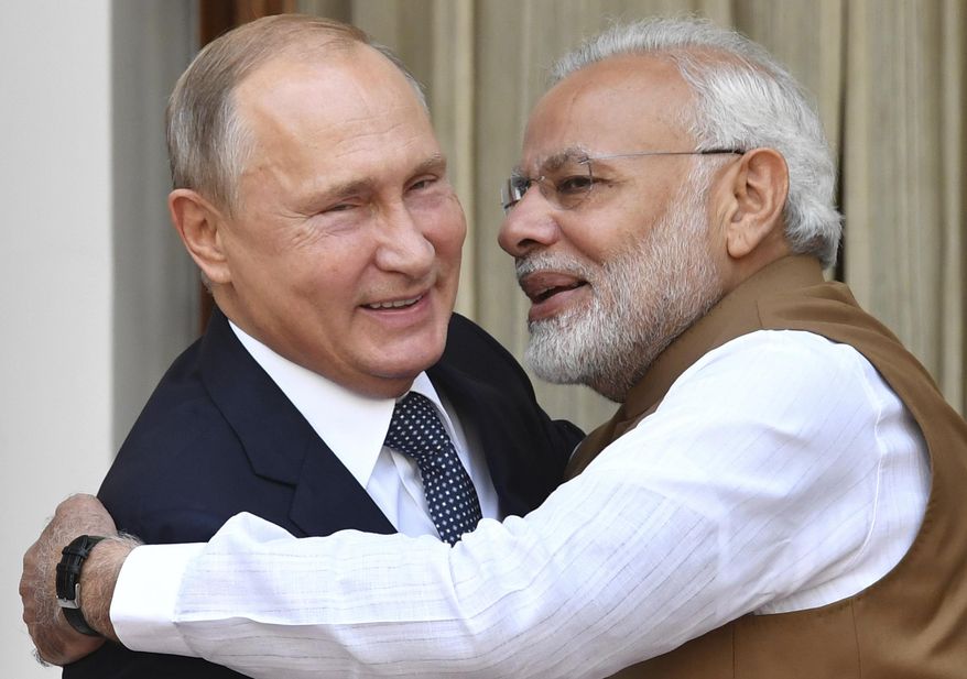 Indian Prime Minister Narendra Modi, right, hugs Russian President Vladimir Putin before their meeting in New Delhi, India, Friday, Oct. 5, 2018. Putin arrived in India on Thursday for a two-day visit during which India is expected to sign a $5 billion deal to buy Russian S-400 air defense systems despite a new U.S. law ordering sanctions on any country trading with Russia's defense and intelligence sectors. (Yuri Kadobnov/Pool Photo via AP)
