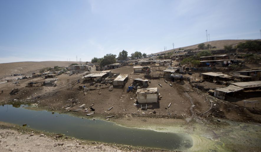 Sewage pool is seen at the Kfar Adumim Beduin hamlet Friday, Oct. 5, 2018. The village slated for demolition is dealing with a large pool of sewage, apparently from a nearby Israeli settlement. The sewage flowed downhill toward Khan al-Ahmar earlier this week, and on Friday was still pooled in a ravine by the West Bank community's corrugated tin shacks. (AP Photo/Majdi Mohammed)