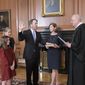 Retired Justice Anthony M. Kennedy, right, administers the Judicial Oath to Judge Brett Kavanaugh in the Justices&#39; Conference Room of the Supreme Court Building. Ashley Kavanaugh holds the Bible. At left are their daughters, Margaret, background, and Liza. (Fred Schilling/Collection of the Supreme Court of the United States via AP)