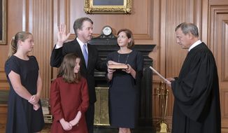 Chief Justice John Roberts, right, administers the Constitutional Oath to Judge Brett Kavanaugh in the Justices&#39; Conference Room of the Supreme Court Building. Ashley Kavanaugh holds the Bible. In the foreground are their daughters, Margaret, left, and Liza. (Fred Schilling/Collection of the Supreme Court of the United States via AP)