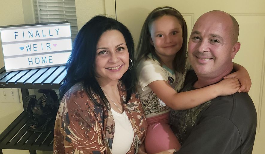 The Weir family, Vennita, left, Athena, center, and Bill take a photograph, at their home on Wednesday, September 27, 2018, in Albuquerque, N.M.  Military families are complaining that this year’s base transfers are the worst in memory as movers are destroying, damaging, losing and stealing their household goods. (Vennita Weir, Source via AP) **FILE**
