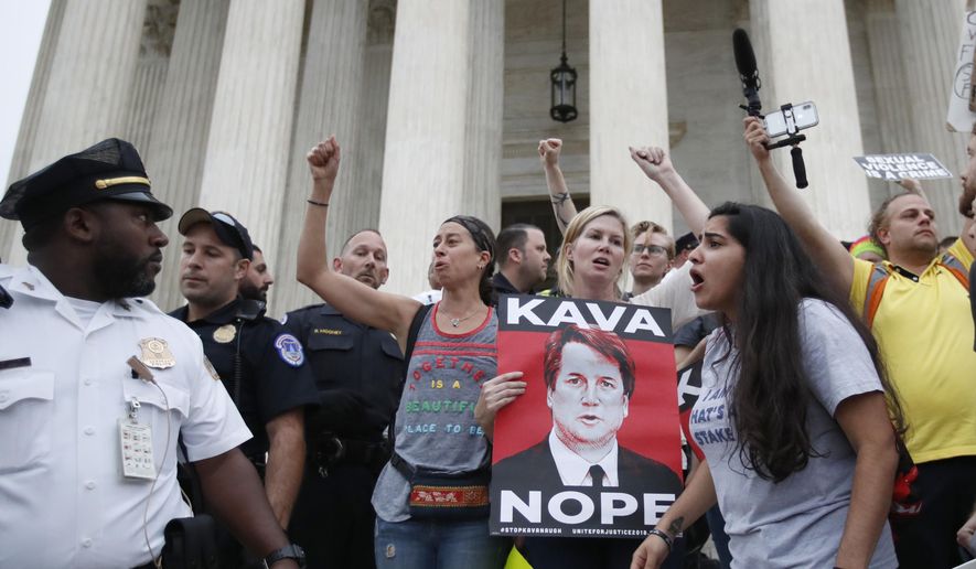 Police move activists as they protest on the steps of the Supreme Court after the confirmation vote of Supreme Court nominee Brett Kavanaugh, on Capitol Hill, Saturday, Oct. 6, 2018 in Washington. (AP Photo/Alex Brandon) **FILE**