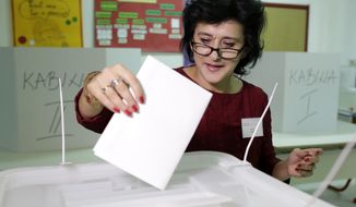 A Bosnian woman casts his vote at poling station in Sarajevo, Bosnia, on Sunday, Oct. 7, 2018. Polls have opened in Bosnia for a general election that could install a pro-Russian nationalist to a top post and cement ethnic divisions drawn in a brutal war more than 20 years ago. Sunday&#39;s vote is seen as a test of whether Bosnia will move toward integration in the European Union and NATO or remain entrenched in war-era rivalries. (AP Photo/Amel Emric)